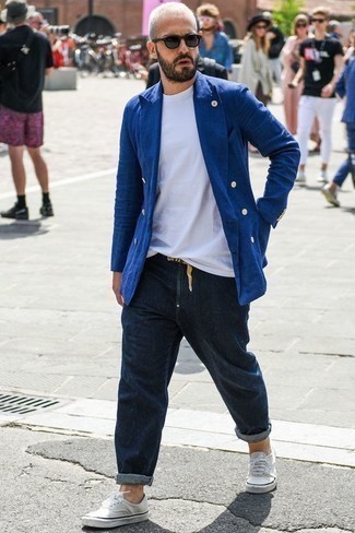 Quale jeans indossare con un blazer blu scuro per un uomo di 40 anni in modo smart-casual: Prova ad abbinare un blazer blu scuro con jeans per un look davvero alla moda. Per distinguerti dagli altri, prova con un paio di sneakers basse di tela bianche.