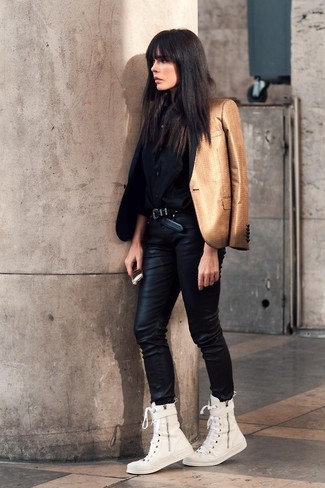 Look alla moda per donna: Blazer dorato, Blusa abbottonata di seta nera, Jeans aderenti in pelle neri, Sneakers alte di tela bianche