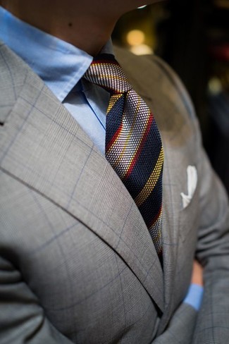 Look alla moda per uomo: Blazer scozzese grigio, Camicia elegante azzurra, Cravatta a righe verticali blu scuro, Fazzoletto da taschino bianco