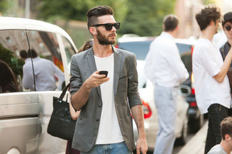 Come indossare e abbinare un blazer grigio scuro per un uomo di 30 anni in modo casual: Abbina un blazer grigio scuro con jeans blu se preferisci uno stile ordinato e alla moda.