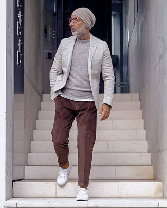 Quale blazer indossare con un maglione girocollo grigio in modo smart-casual: Vestiti con un blazer e un maglione girocollo grigio per un look da sfoggiare sul lavoro. Prova con un paio di sneakers basse di tela bianche per un tocco più rilassato.