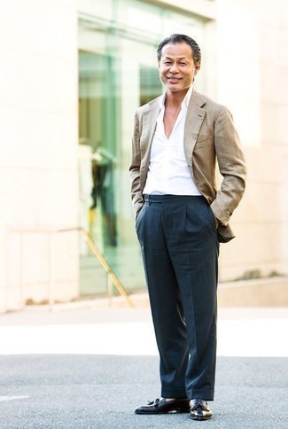 Come indossare e abbinare un blazer beige per un uomo di 40 anni: Prova ad abbinare un blazer beige con pantaloni eleganti blu scuro come un vero gentiluomo. Mocassini con nappine in pelle neri sono una splendida scelta per completare il look.