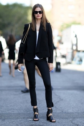 Quale jeans aderenti indossare con un blazer nero in modo smart-casual: Per un outfit quotidiano pieno di carattere e personalità, indossa un blazer nero e jeans aderenti. Questo outfit si abbina perfettamente a un paio di sandali con tacco in pelle neri.