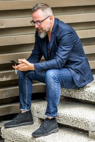 Quale jeans indossare con chukka nere per un uomo di 50 anni in modo smart-casual: Distinguiti anche negli ambienti più alla moda con un blazer blu scuro e jeans. Ispirati all'eleganza di Luca Argentero e completa il tuo look con un paio di chukka nere.