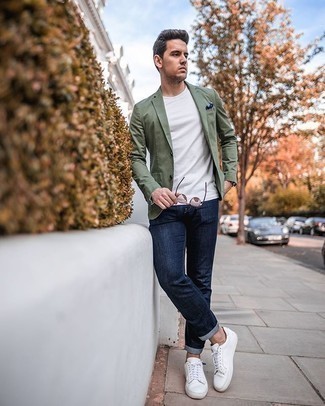 Come indossare e abbinare un blazer verde oliva: Potresti indossare un blazer verde oliva e jeans blu scuro per un drink dopo il lavoro. Per un look più rilassato, scegli un paio di sneakers basse di tela bianche come calzature.