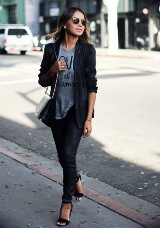 Look alla moda per donna: Blazer nero, T-shirt girocollo stampata grigia, Pantaloni skinny neri, Sandali con tacco in pelle neri