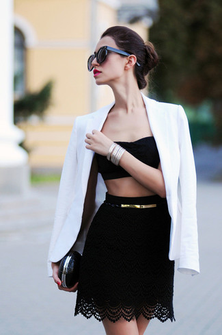 Look alla moda per donna: Blazer bianco, Top corto di pizzo nero, Minigonna di pizzo nera, Pochette in pelle nera