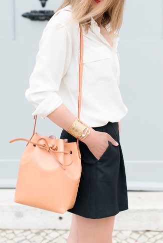 Come indossare e abbinare una borsa a secchiello in modo smart-casual: Prova a combinare una blusa abbottonata beige con una borsa a secchiello per un'atmosfera casual-cool.