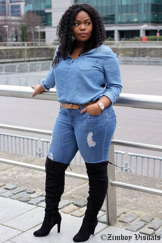Look alla moda per donna: Blusa abbottonata di jeans azzurra, Jeans aderenti strappati blu, Stivali sopra il ginocchio in pelle scamosciata neri, Cintura in pelle marrone chiaro