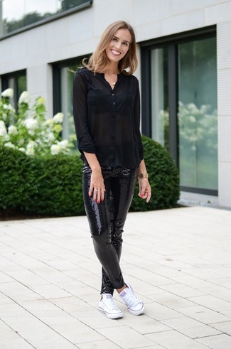Look alla moda per donna: Blusa abbottonata nera, Leggings con paillettes neri, Sneakers basse di tela bianche, Orologio dorato