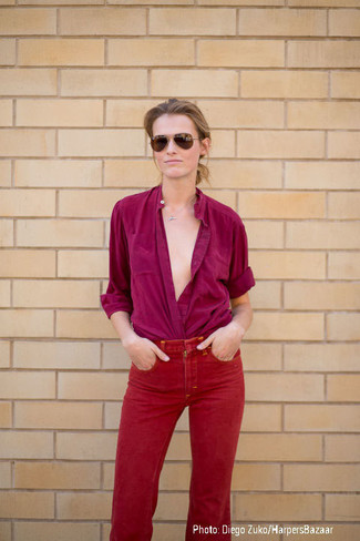 Come indossare e abbinare jeans rossi in modo smart-casual: Questo abbinamento di una blusa abbottonata viola melanzana e jeans rossi è perfetto per il tempo libero.