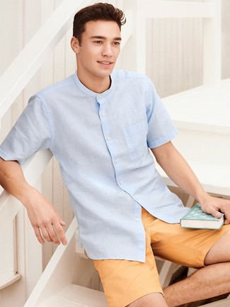 Come indossare e abbinare pantaloncini senapi per un uomo di 20 anni: Prova a combinare una camicia a maniche corte azzurra con pantaloncini senapi per un look raffinato per il tempo libero.