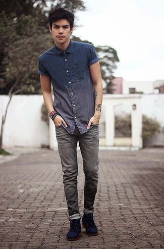 Quale jeans indossare con chukka blu per un uomo di 20 anni: Per un outfit quotidiano pieno di carattere e personalità, abbina una camicia a maniche corte in chambray blu scuro con jeans. Calza un paio di chukka blu per dare un tocco classico al completo.