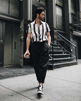 Look alla moda per uomo: Camicia a maniche corte a righe verticali nera e bianca, Chino neri, Sneakers alte di tela nere, Occhiali da sole neri