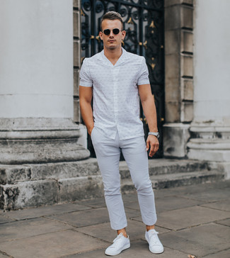 Look alla moda per uomo: Camicia a maniche corte stampata bianca, Chino grigi, Sneakers basse bianche, Occhiali da sole neri