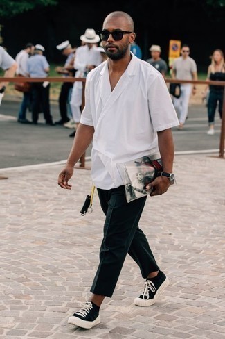 Look alla moda per uomo: Camicia a maniche corte bianca, Chino blu scuro, Sneakers basse di tela nere e bianche, Occhiali da sole neri