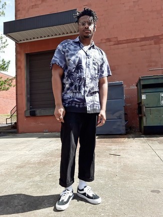 Look alla moda per uomo: Camicia a maniche corte stampata grigia, Chino neri, Sneakers basse di tela nere e bianche, Occhiali da sole trasparenti