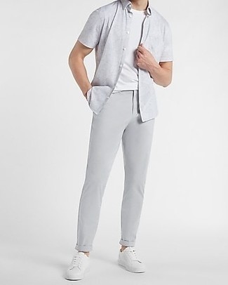 Look alla moda per uomo: Camicia a maniche corte grigia, T-shirt girocollo bianca, Chino grigi, Sneakers basse di tela bianche
