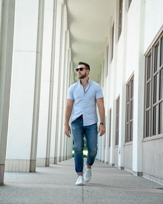 Come indossare e abbinare jeans strappati blu per un uomo di 30 anni in modo rilassato: Vestiti con una camicia a maniche corte azzurra e jeans strappati blu per un look perfetto per il weekend. Sneakers basse di tela bianche e blu scuro daranno lucentezza a un look discreto.