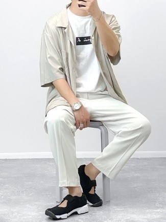 Look alla moda per uomo: Camicia a maniche corte grigia, T-shirt girocollo stampata bianca e nera, Chino bianchi, Scarpe sportive nere e bianche