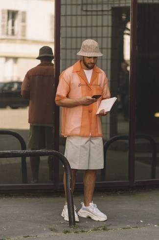 Trend da uomo 2022: Per un outfit quotidiano pieno di carattere e personalità, mostra il tuo stile in una camicia a maniche corte in rete arancione.