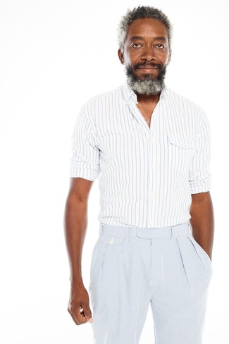 Come indossare e abbinare una camicia a maniche lunghe a righe verticali per un uomo di 40 anni: Abbina una camicia a maniche lunghe a righe verticali con pantaloni eleganti di seersucker a righe verticali azzurri, perfetto per il lavoro.