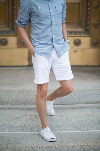 Look alla moda per uomo: Camicia a maniche lunghe in chambray azzurra, Pantaloncini bianchi, Sneakers basse di tela bianche, Salvapiede