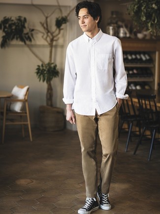 Look alla moda per uomo: Camicia a maniche lunghe bianca, Chino marrone chiaro, Sneakers alte di tela nere e bianche