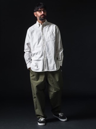 Moda uomo anni 40: Mostra il tuo stile in una camicia a maniche lunghe bianca con chino verde oliva per affrontare con facilità la tua giornata. Per distinguerti dagli altri, calza un paio di sneakers basse di tela nere e bianche.