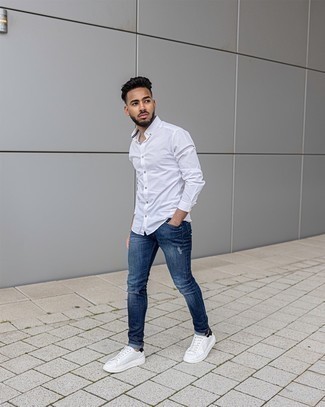 Quale jeans aderenti indossare con sneakers basse bianche e blu quando fa caldo: Punta su una camicia a maniche lunghe bianca e jeans aderenti per un outfit rilassato ma alla moda. Perfeziona questo look con un paio di sneakers basse bianche e blu.