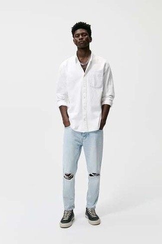 Come indossare e abbinare jeans azzurri per un uomo di 20 anni quando fa caldo: Abbina una camicia a maniche lunghe bianca con jeans azzurri per un look trendy e alla mano. Sneakers basse di tela nere e bianche sono una validissima scelta per completare il look.