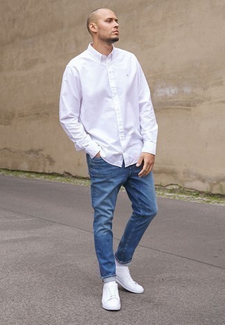 Quale sneakers basse indossare con jeans blu in estate 2024: Questa combinazione di una camicia a maniche lunghe bianca e jeans blu è perfetta per il tempo libero. Sneakers basse sono una valida scelta per completare il look. Ecco un outfit stupendo per l’estate.