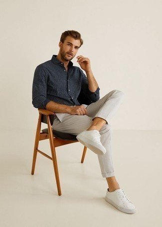 Look alla moda per uomo: Camicia a maniche lunghe blu scuro, Chino grigi, Sneakers basse di tela bianche