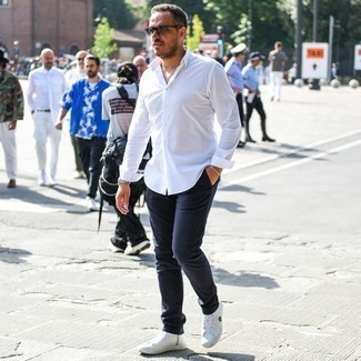 Look alla moda per uomo: Camicia a maniche lunghe bianca, Chino blu scuro, Sneakers alte di tela bianche, Occhiali da sole grigi