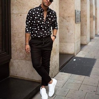 Look alla moda per uomo: Camicia a maniche lunghe a pois nera e bianca, Chino neri, Sneakers basse di tela bianche, Occhiali da sole neri
