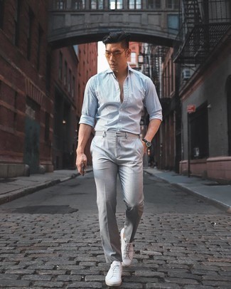Look alla moda per uomo: Camicia a maniche lunghe a quadri bianca e blu scuro, Chino grigi, Sneakers basse di tela bianche, Occhiali da sole arancioni