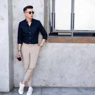 Look alla moda per uomo: Camicia a maniche lunghe blu scuro, Chino beige, Sneakers basse di tela bianche, Occhiali da sole neri