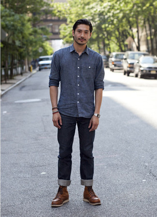 Look alla moda per uomo: Camicia a maniche lunghe in chambray blu, Jeans blu scuro, Stivali da lavoro in pelle marroni