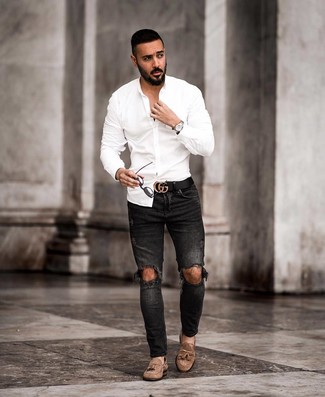 Look alla moda per uomo: Camicia a maniche lunghe bianca, Jeans aderenti strappati neri, Mocassini con nappine in pelle scamosciata marroni, Cintura in pelle nera