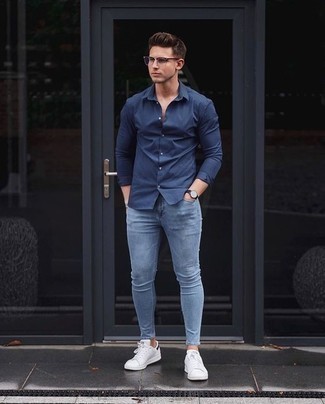 Come indossare e abbinare jeans aderenti azzurri per un uomo di 20 anni: Mostra il tuo stile in una camicia a maniche lunghe blu scuro con jeans aderenti azzurri per un look spensierato e alla moda. Sneakers basse in pelle bianche e nere sono una interessante scelta per completare il look.