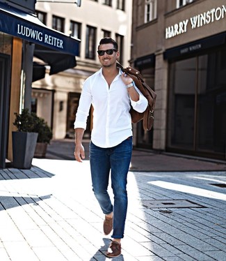 Look alla moda per uomo: Camicia a maniche lunghe bianca, Jeans blu, Scarpe da barca in pelle marroni, Borsone in pelle marrone