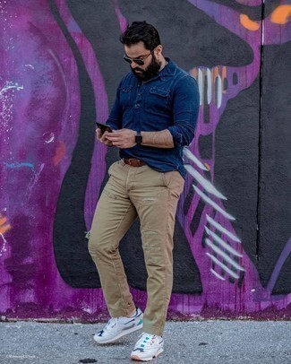 Come indossare e abbinare jeans marrone chiaro: Vestiti con una camicia a maniche lunghe in chambray blu scuro e jeans marrone chiaro per una sensazione di semplicità e spensieratezza. Scarpe sportive bianche renderanno il tuo look davvero alla moda.