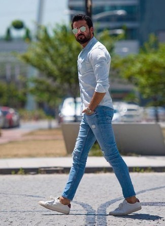 Come indossare e abbinare jeans strappati azzurri per un uomo di 40 anni: Opta per una camicia a maniche lunghe azzurra e jeans strappati azzurri per un look comfy-casual. Calza un paio di sneakers basse di tela bianche e rosse per dare un tocco classico al completo.