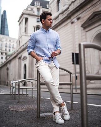 Look alla moda per uomo: Camicia a maniche lunghe di lino azzurra, Jeans bianchi, Sneakers basse di tela bianche, Occhiali da sole marroni