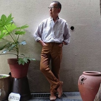 Moda uomo anni 60: Prova ad abbinare una camicia a maniche lunghe a quadri bianca e nera con jeans terracotta per un outfit comodo ma studiato con cura. Questo outfit si abbina perfettamente a un paio di sneakers basse di tela marroni.