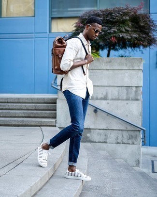 Quale jeans indossare con una camicia a maniche lunghe beige: Opta per una camicia a maniche lunghe beige e jeans per un look semplice, da indossare ogni giorno. Rifinisci questo look con un paio di sneakers basse di tela a righe orizzontali grigie.
