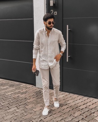 Look alla moda per uomo: Camicia a maniche lunghe a righe verticali beige, Jeans beige, Sneakers basse di tela bianche, Occhiali da sole marrone scuro