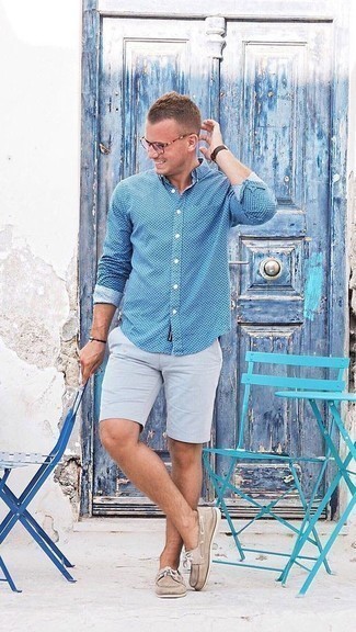 Look alla moda per uomo: Camicia a maniche lunghe a pois blu, Pantaloncini grigi, Scarpe da barca in pelle marrone chiaro, Occhiali da sole trasparenti