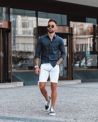 Look alla moda per uomo: Camicia a maniche lunghe blu scuro, Pantaloncini bianchi, Sneakers basse di tela blu scuro e bianche, Occhiali da sole neri
