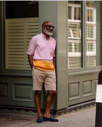 Come indossare e abbinare una camicia rosa per un uomo di 50 anni: Abbina una camicia rosa con pantaloncini di jeans beige per un look semplice, da indossare ogni giorno. Scegli un paio di mocassini eleganti in pelle scamosciata blu scuro per dare un tocco classico al completo.